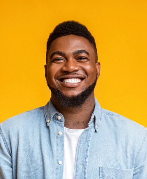 man with white teeth in front of an orange background