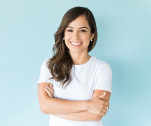 woman smiling in front of a blue background 